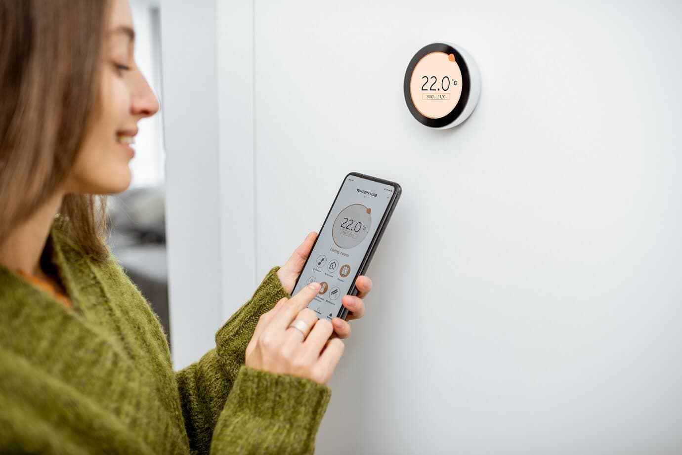 Smart Home Frau steuert Heizung Smartphone